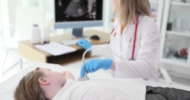 Doktor çocuğa yakın plan bir kalp ultrasonu yaptırıyor. Vasküler hastalıkların teşhisi, yavaşlama