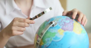 Bir kadın dünyaya büyüteçten bakıyor, yakın plan. Cazibe arayışı, seyahat kavramı