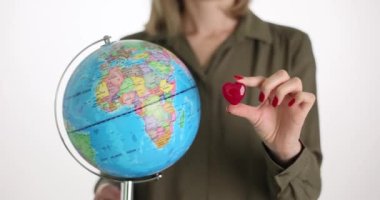Bir iş kadınının elinde bir küre, kırmızı bir kalp ve yakın plan bir fotoğraf var. Ekoloji koruması, gezegene duyulan sevgi, kavram