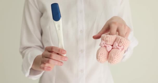 女性は妊娠検査とおっぱい クローズアップを保持しています 子供の誕生を待つ コンセプト — ストック動画