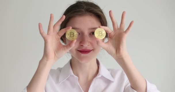 一个快乐的女孩能让比特币的眼睛近距离接触到她 成功的交易 加密货币 慢动作 — 图库视频影像