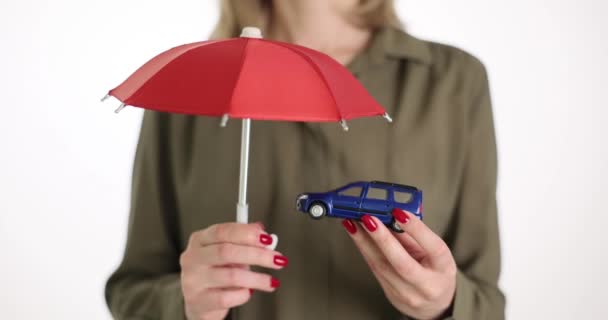 Bir Kadını Oyuncak Bir Arabanın Üzerinde Kırmızı Bir Şemsiye Tutar — Stok video