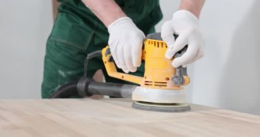 Erkek eller, tahtadaki öğütme makinesini hareket ettirir. Yakın plan. Marangozlar, tamir için hazırlık.