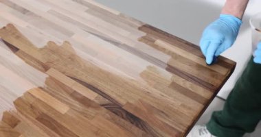 Erkek eller ahşap bir yüzeye cila sürerler, yakın plan. Marangozlar, mutfak tezgahlarının tamiri.