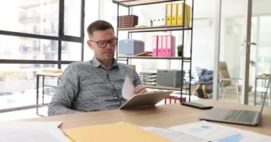 Ofisteki yorgun bir iş adamı, yakın plan raporları izler. İş yerinde duygusal gerileme, izleme