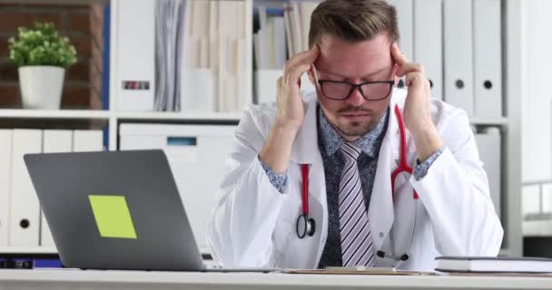 Κουρασμένος Γιατρός Κάθεται Μπροστά Από Laptop Και Μασάζ Ναός Του — Αρχείο Βίντεο