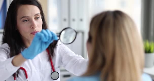 Mulher Médico Olhando Para Rosto Paciente Através Lupa Filme Câmera — Vídeo de Stock