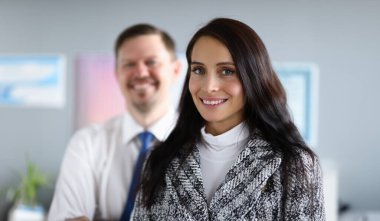 Neşeli bir ofis çalışanının portresi. Gülümseyen mutlu esmer yönetici ve kabinede poz veren erkek çalışan. İş ortakları. Ekonomi ve finans şirketi kavramı
