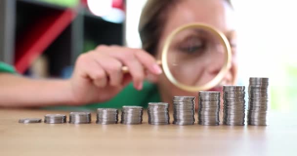 兴奋的贪婪的女商人通过放大镜看着堆积如山的硬币的情感 财政现金收入的增长 — 图库视频影像