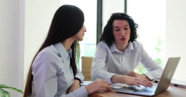 Erkek öğretmen dizüstü bilgisayarı gösteriyor, yeni çalışanlara öğretiyor ve kurumsal yazılıma yardım ediyor. Ciddi akıl hocası tren işçisi