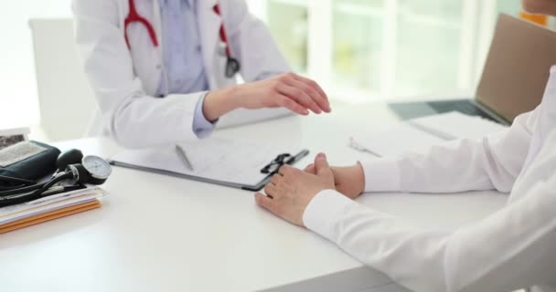 予約時にクリニックで患者の手を保持フレンドリーな女性医師 検査の結果は陽性で 落ち着いています — ストック動画