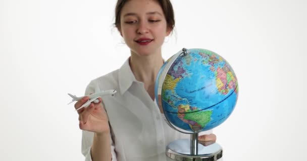 世界の飛行機を旅行し 航空券を販売 世界地図を手に飛行機や地球を保持する美しい女の子 — ストック動画