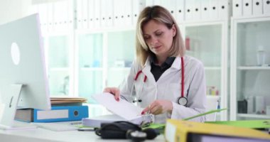 Doktor belgeleri klinikteki dosyalara koyar. Tıbbi kayıtlarla çalışan bir terapist ya da hemşire.