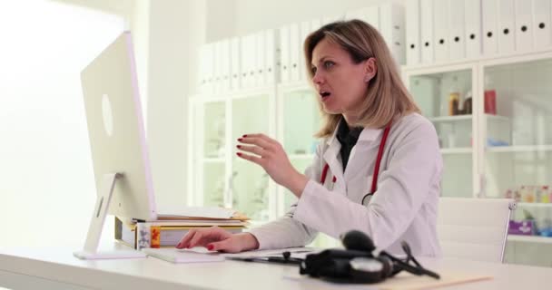 不快乐的疯狂女医生在医院使用电脑混淆操作问题或设备垃圾邮件 目瞪口呆的医生看着电脑屏幕 — 图库视频影像
