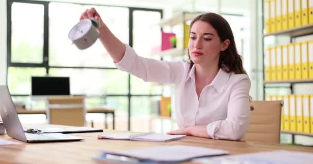 ビジネスの女性は目覚まし時計をオフィスのテーブルに置きます 作業時間の締め切りと時間管理 — ストック動画