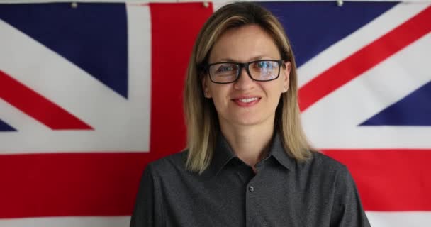英国の縞模様の旗を背景に美しい知的少女の肖像画 大学生コースコンセプト — ストック動画