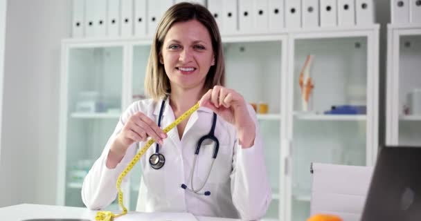 在诊所拿着测量磁带微笑的营养师医生 适当的营养和饮食 — 图库视频影像