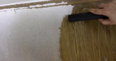 Ustanın eli, elektrikli süpürgeyle inşaat alçı tozu topluyor. Yenilemeden sonra temizlik hizmetleri