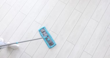 Elleri paspas tutan ve yerleri yıkayan adamın üst görüntüsü. Temizlik hizmetleri ve ofis veya ev temizliği