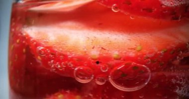 Bardakta ıslak su damlaları ve köpüklü makro shot ile iştah açıcı çilek kokteyli. Tropikal soda ferahlatıcı.