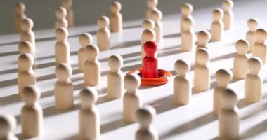 Ahşap insan heykelleri arasında kırmızı bir şekil var. Bireysellik, eşsizlik, liderlik ve insanları kurtarmak.