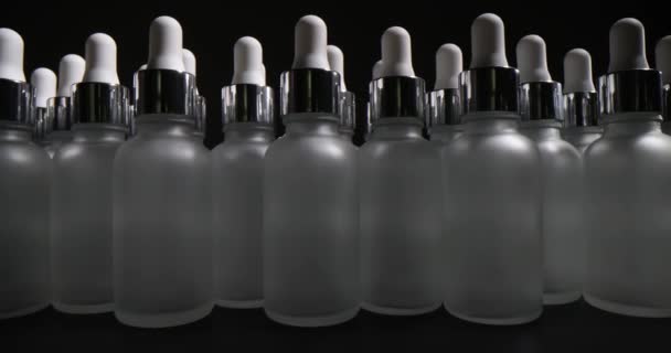 Много Пустых Бутылок Пипетками Черном Фоне Бутылки Предназначенные Хранения Косметики — стоковое видео