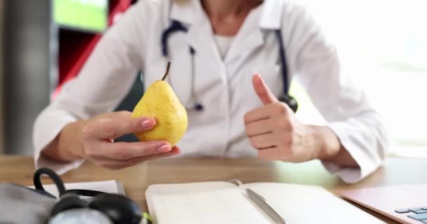 栄養士は新鮮な有機梨と親指を持っています 健康的な食事のアドバイスとビタミン — ストック動画