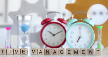 Zaman yönetimi metni ve masadaki farklı saatler. Fazla mesai süresi ve çalışma programı kavramı