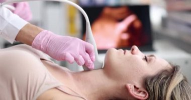 Genç beyaz kadın, kadın doktorun ofisinde ultrason ile tiroid bezi alınıyor. Kadın hasta hastane konseptinde boyun ultrasonu yapıyor.