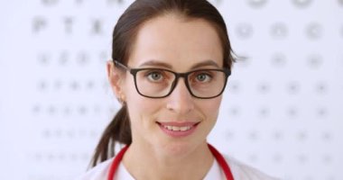 Gözlüklü kadın göz doktoru portresi. Arka planda, Masa 4-K filmi ağır çekim. Miyopya düzeltme gözlüğü ve lens konsepti