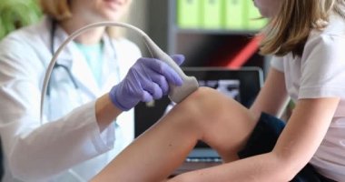 Fizyoterapist, çocuk hastaların bacaklarına ve dizlerine ultrason uygular. Çocuk konseptinde diz ağrısı teşhisi