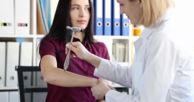 Doktor hasta elinde çekiçle sinir reflekslerini kontrol ediyor. Nörolojik inceleme tekniği