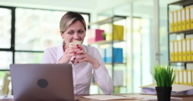 Genç bir kadın işyerinde nefis shawarma yiyor. İşte hızlı öğle yemekleri.