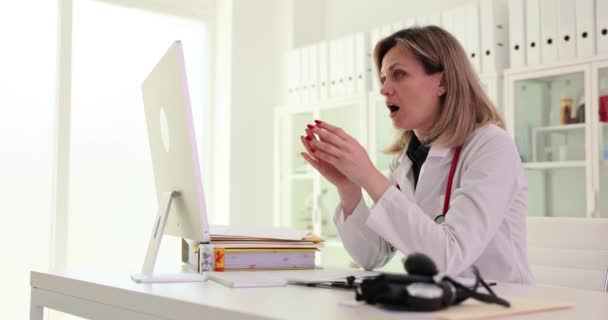 沮丧的护士在诊所的电脑上工作 不快乐的疯狂女医生在医院使用电脑混淆操作问题或设备垃圾邮件 — 图库视频影像
