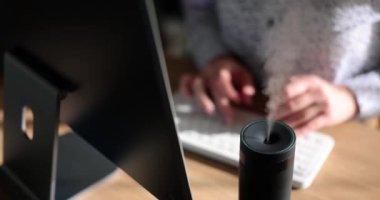 Siyah nemlendirici masaya buhar püskürtür. Ofis işyerinde modern hava temizleyici