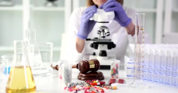 科学者の専門家は研究室で顕微鏡を見る 医薬品分野における法医学検査 — ストック動画