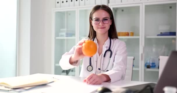 维生素C有免疫力 持橙子并推荐新鲜水果的微笑女性营养师医生的画像 — 图库视频影像