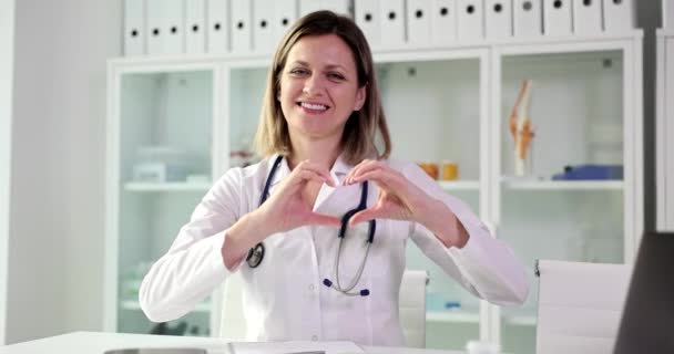 Portrait Smiling Female Doctor Looking Camera Showing Finger Heart Sign — Stock Video
