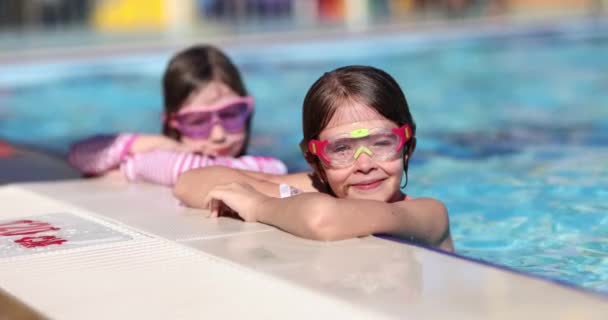 可爱的小女孩戴着粉色眼镜面具在游泳池里玩耍 儿童暑期游泳池度假 — 图库视频影像