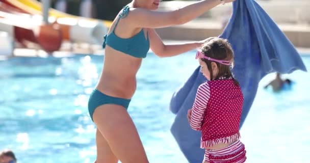 洗过澡后 冻僵的女孩洗澡后感到快乐 妈妈把女儿包在游泳池边 — 图库视频影像