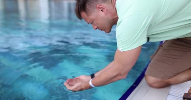 男はプールの手の手のひらにきれいな水を収集します 夏のプールできれいな水 — ストック動画