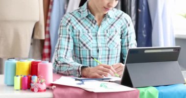 Yaratıcı kadın moda tasarımcısı projelerin taslaklarını çiziyor. Terzi kadın elbise çizimleri yapıyor.