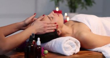 Kaplıcada yüz masajından hoşlanan güzel bir genç kadın. Yüz bakımı konsepti