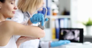 Doktor klinikte dirsek eklemini ultrasonla muayene ediyor. Dirsek ağrıları ve teşhisler