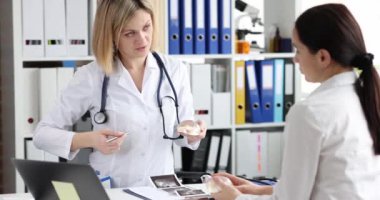 Klinikteki hastaya silikon göğüs büyütme implantı gösteren bir doktor. Estetik cerrahi konsepti