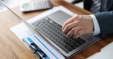 Dizüstü bilgisayarda yazan ve hesap makinesine güvenen bir iş adamı 4K 'lık filmi yavaş çekimde çeker. İş konseptinde profesyonel sigorta