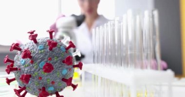 Coronavirus 'un yapay modeli, kadın kimyagerin önünde, mikroskop 4K filmli ağır çekimde yatıyor. Yeni türler üzerinde çalışmak Corona virüsü konsepti