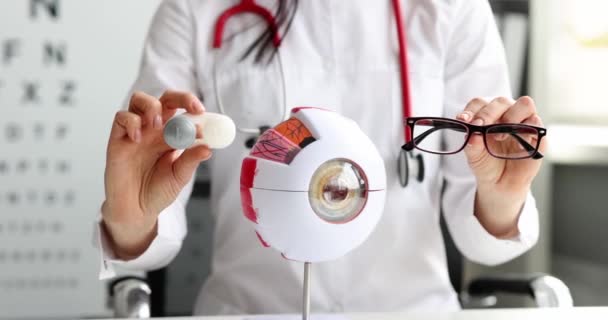 Läkare Oftalmolog Hålla Behållare Med Kontaktlinser Och Glasögon Framför Konstgjorda — Stockvideo