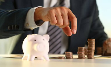 El iş adamı domuza PIN para koyarak. Gelecek eğitim kredi ya da ipotek kredi harcama tatil kavramının rüya etkili satın alma finansal risk ve güvenlik