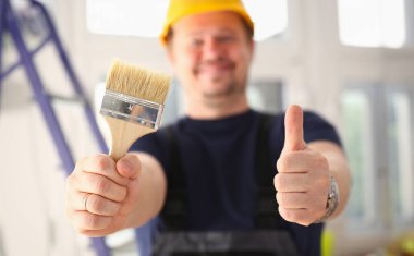 Silah alt boya fırçası ve gösteri closeup yukarı işaretiyle onaylamak tutun. El ile iş DIY ilham sanayi başlangıç fikir tamir dükkanı baret endüstriyel eğitim meslek kariyer kavramı